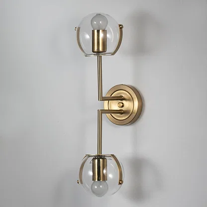 Wall sconce with double clear glass globes and gold finish frame perfect for bedroom living room and luxury modern interiors.