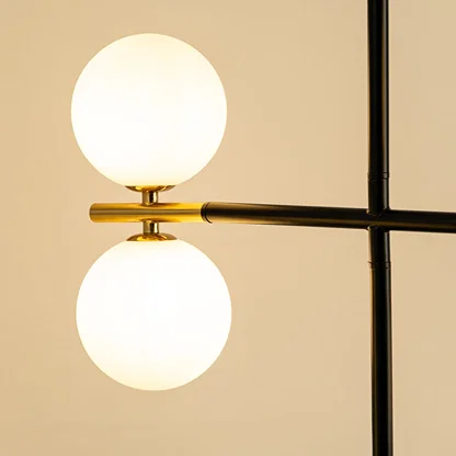 Frosted glass globe chandelier with gold accents and black metal frame showcasing elegant modern lighting craftsmanship.