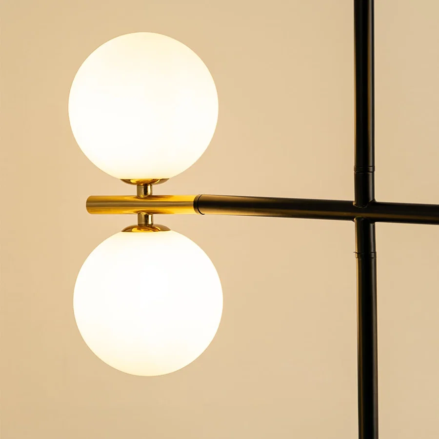 Frosted glass globe chandelier with gold accents and black metal frame showcasing elegant modern lighting craftsmanship.
