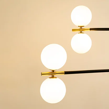 Frosted glass globe shades with gold metal detailing highlighting premium materials and contemporary chandelier design.