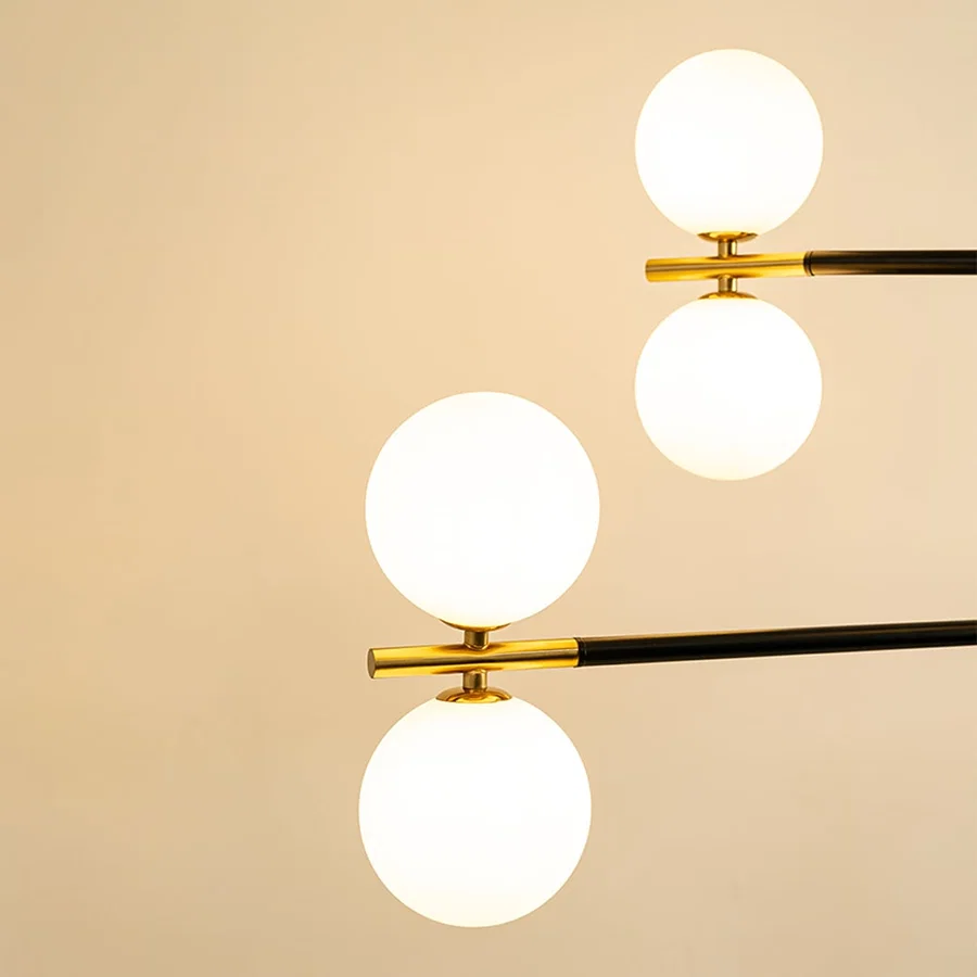 Frosted glass globe shades with gold metal detailing highlighting premium materials and contemporary chandelier design.