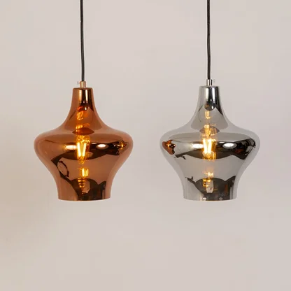 Copper and silver metal pendant lights illuminated to showcase luxury ceiling lighting with reflective contemporary styling.