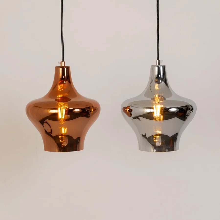 Copper and silver metal pendant lights illuminated to showcase luxury ceiling lighting with reflective contemporary styling.