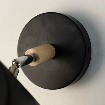 Contemporary black metal wall light with wooden accent detailing for modern interior decor.