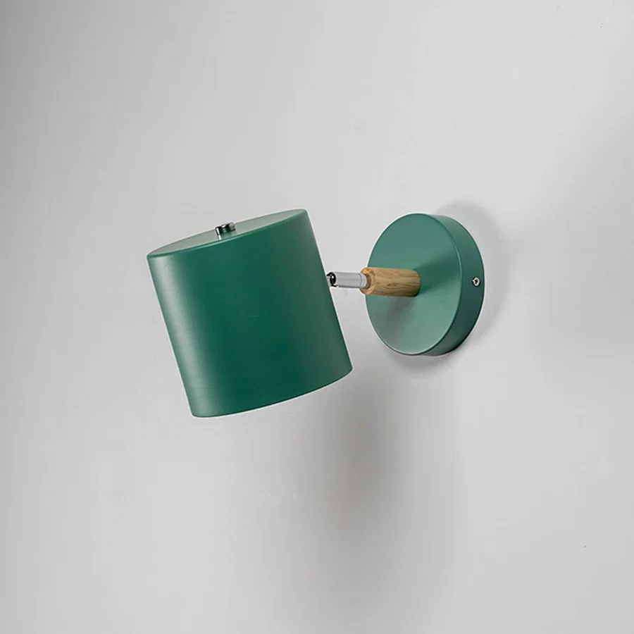 Green metal wall light shown unlit on white background with clean cylindrical shade for modern minimalist interior lighting.