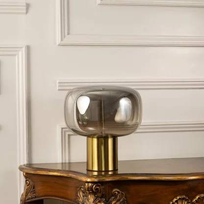 Halo glass dome table lamp with golden base displayed on plain background with light turned off for modern decorative styling.