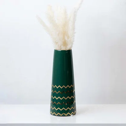 Elegant green ceramic vase with golden zigzag design styled with pampas grass for modern home decor.