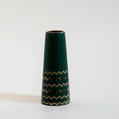Dark green ceramic decorative vase with gold zigzag pattern for shelf styling and contemporary home decor displays.