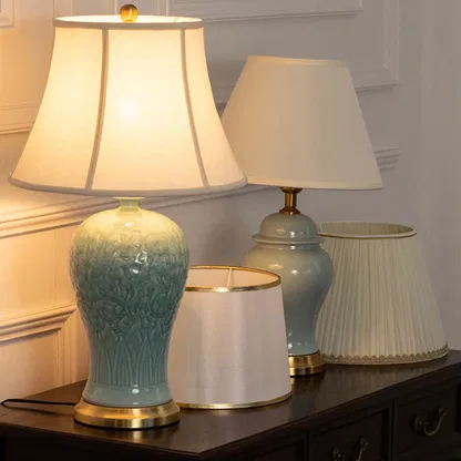 Turquoise ceramic table lamp with fabric shade displayed on a console table creating elegant traditional ambient lighting indoors.