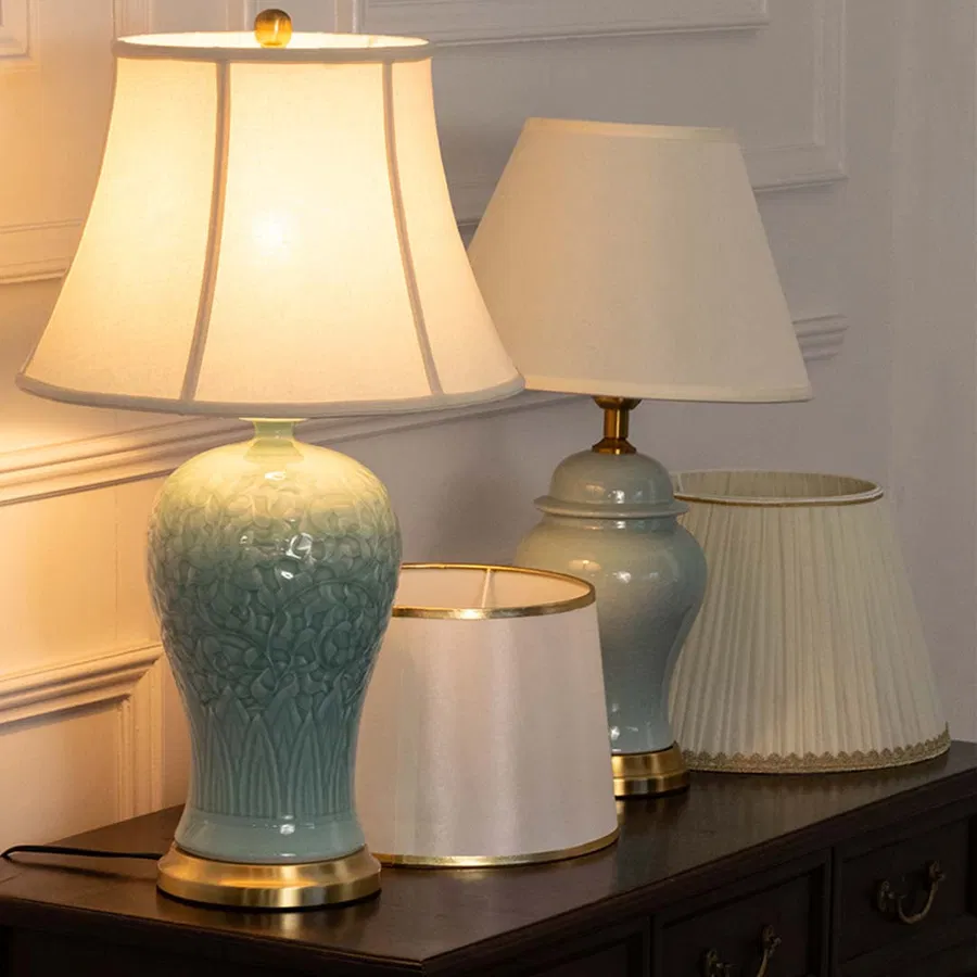 Turquoise ceramic table lamp with fabric shade displayed on a console table creating elegant traditional ambient lighting indoors.