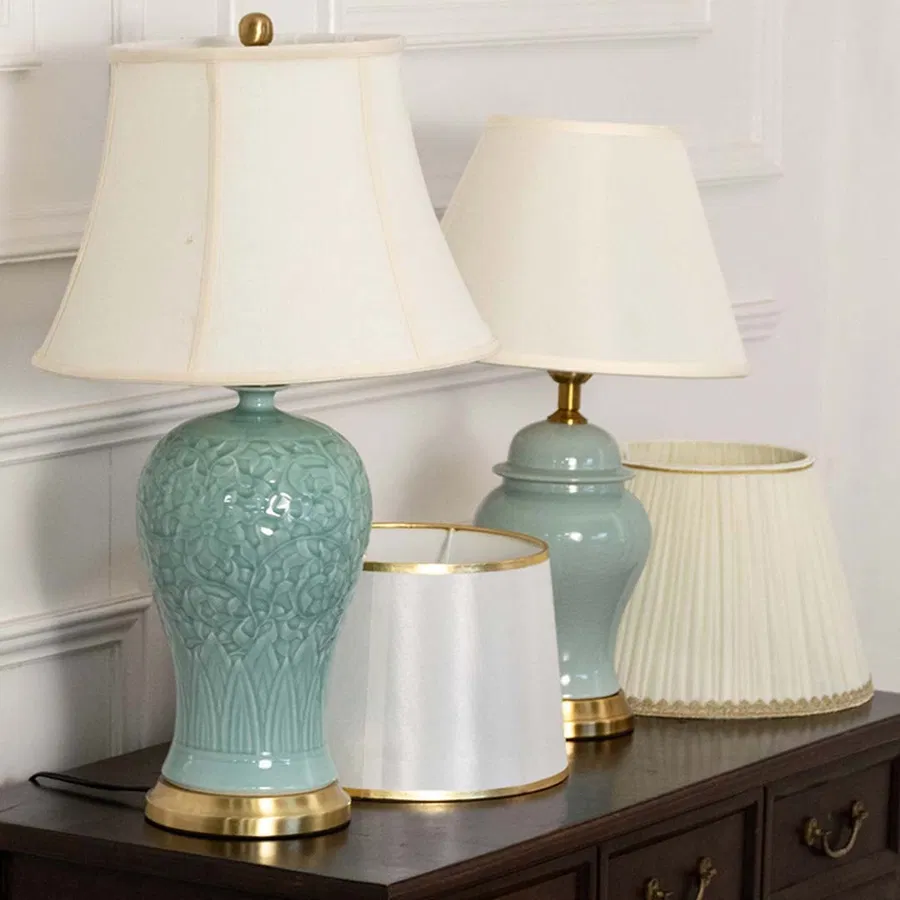 Elegant two blue ceramic table lamps with gold metal base and white fabric shade adds a soft refined touch to home decor.