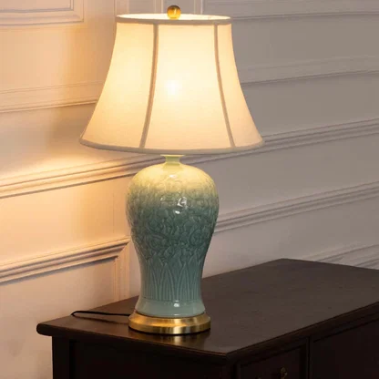 Pastel blue ceramic lamp with gold base and smooth white shade emits a warm ambient glow enhancing elegant and minimal interiors beautifully.