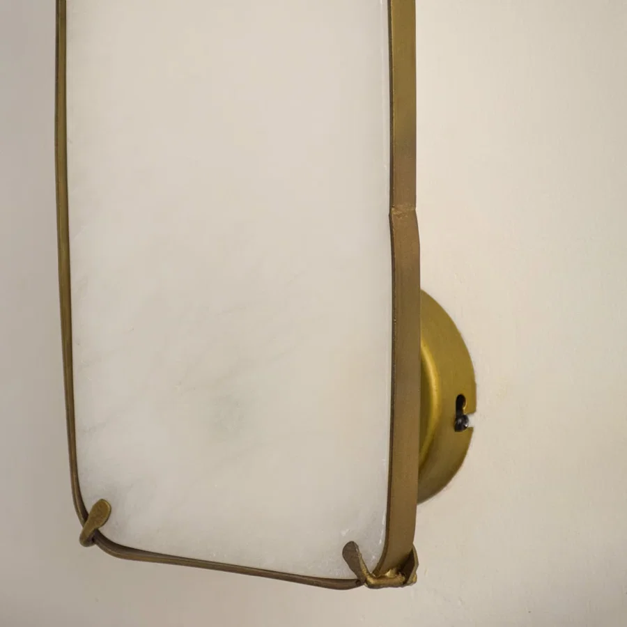 Closeup of marble and gold metal wall light for elegant hallway and premium decor styling spaces.