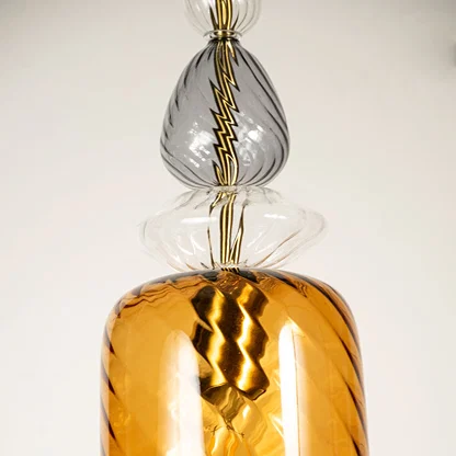 Amber glass pendant light closeup showcasing textured glass finish and premium craftsmanship with warm illumination.