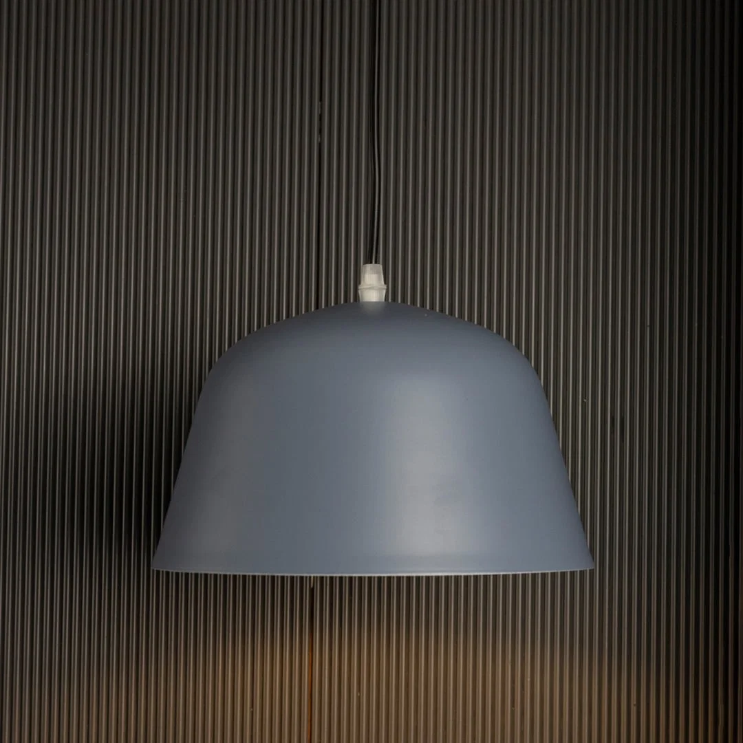 Matte blue dome pendant light on black background showcasing its sleek curved shade and soft matte finish.