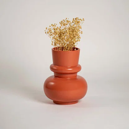 Terracotta orange modern decorative vase styled in a warm interior adding bold contemporary decor to consoles shelves and stylish living spaces.