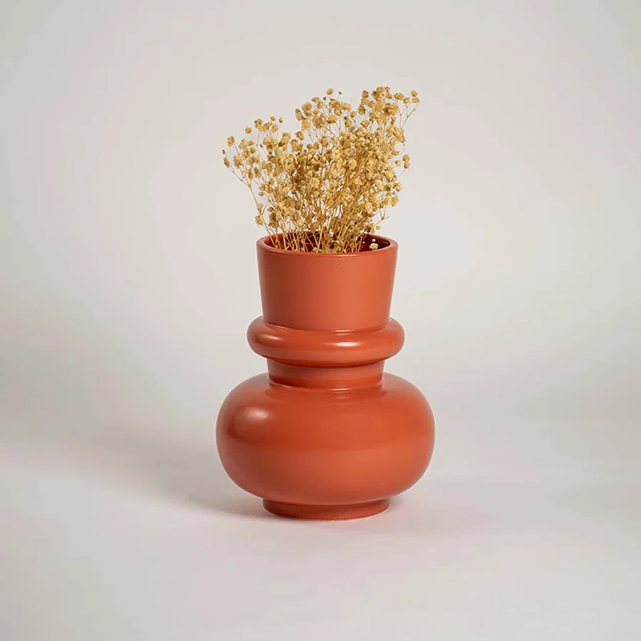 Terracotta orange modern decorative vase styled in a warm interior adding bold contemporary decor to consoles shelves and stylish living spaces.