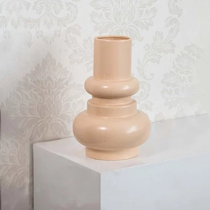 Peach sculptural ceramic vase displayed against a clean white background  highlighting its smooth curves and modern minimalist form.