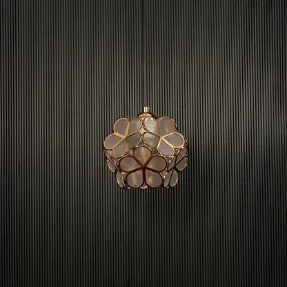 Modern gold flower pendant light displayed on dark background with light off highlighting elegant design details.