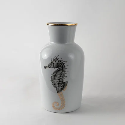White ceramic decorative vase with black seahorse artwork for elegant shelf styling and contemporary home decor displays.