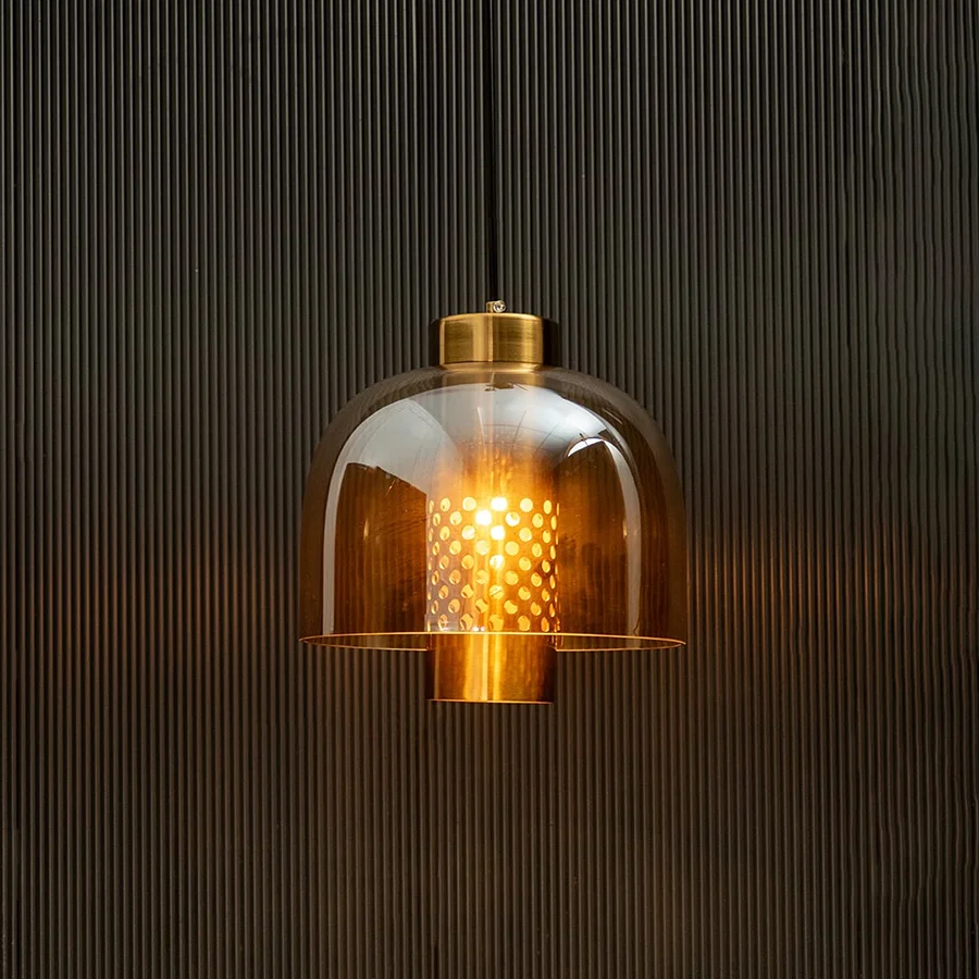 Amber glass pendant light glowing warmly with gold metal accents for luxurious indoor ceiling decor.