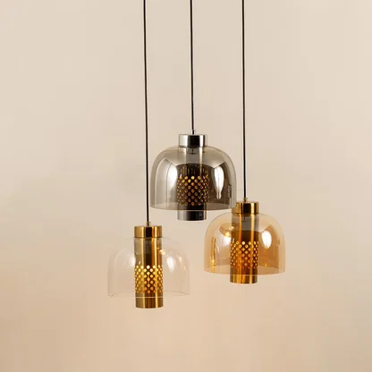 Amber smoke and gold metal pendant lights illuminated to showcase luxury decorative ceiling lighting appeal.