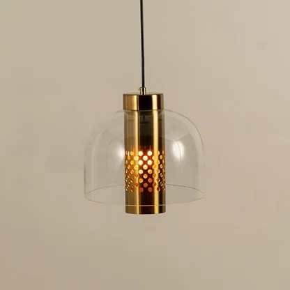 Closeup of pendant light with gold metal holder and clear glass shade showcasing warm light and premium design for interior decor.