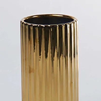 A closeup of a gold ribbed vase capturing its glossy reflective texture and detailed finish creating a refined modern look with elegant highlights.