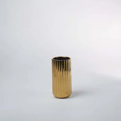 Gold textured metal planter pot with cylindrical silhouette for elegant indoor plant styling and luxury decor.