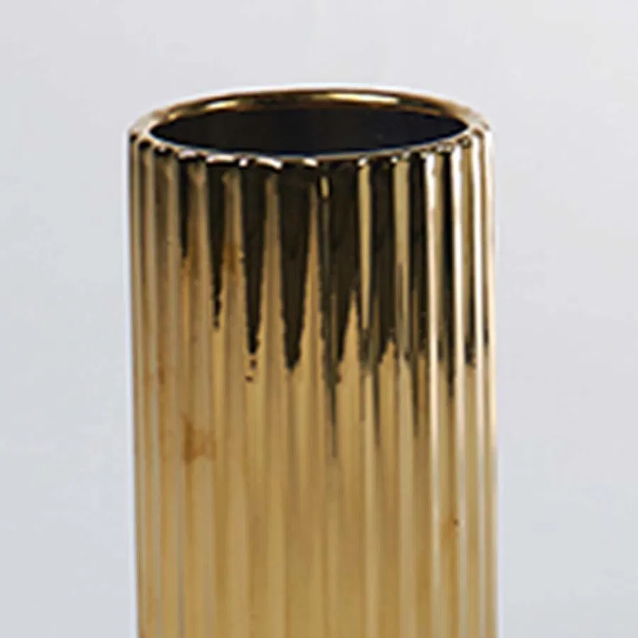 A detailed view of a gold ribbed vase capturing its glossy texture and refined finish creating a closeup look that enhances its elegant modern style.
