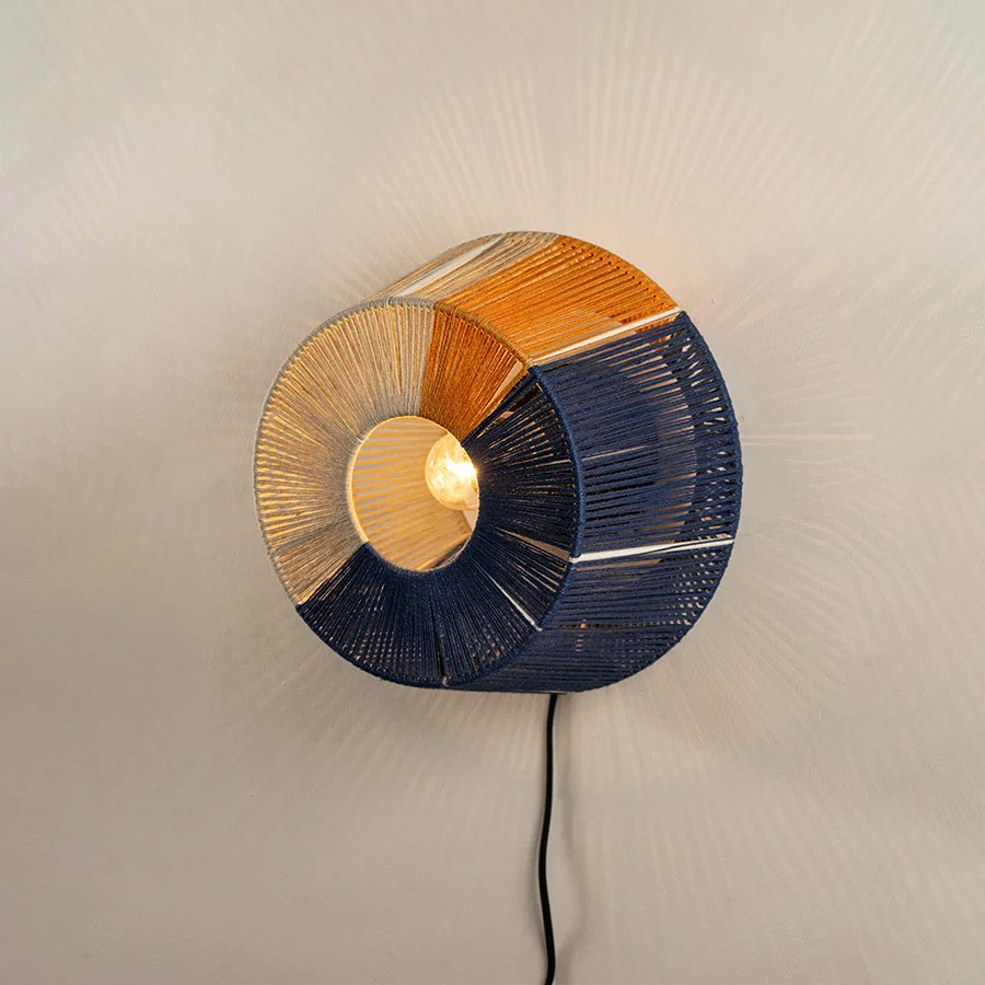 Wall light with blue textured shade and gold accent emitting warm glow ideal for modern bedroom or hallway wall decor placement.