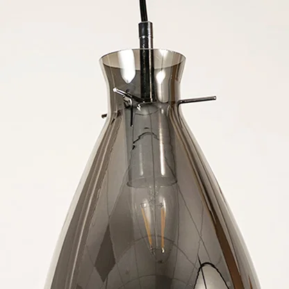 Smoked glass pendant light with exposed bulb detail showcasing elegant craftsmanship and modern decorative lighting.