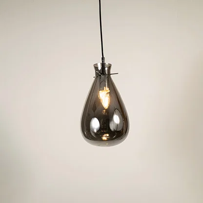 Smoked glass pendant light with exposed bulb detail showcasing elegant craftsmanship and contemporary lighting design.