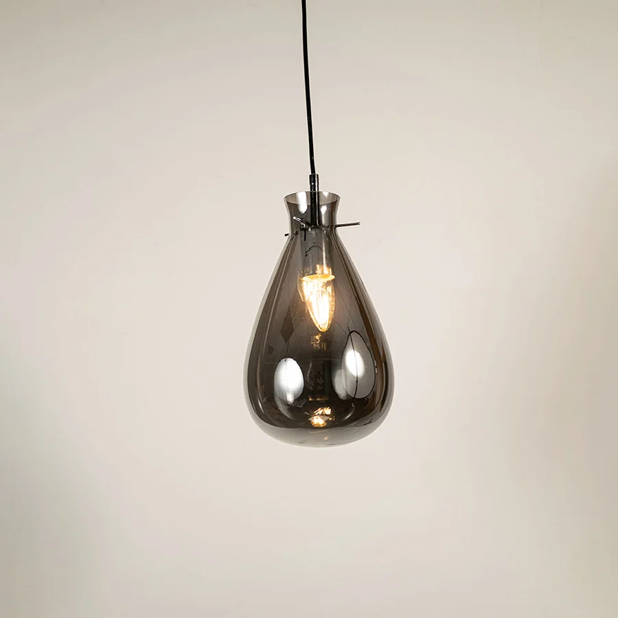 Smoked glass pendant light with exposed bulb detail showcasing elegant craftsmanship and contemporary lighting design.