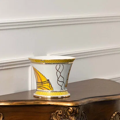 White ceramic decorative jar with gold abstract artwork displayed on a console table for luxury home decor styling.