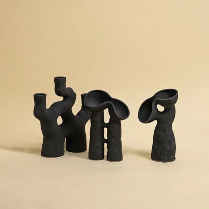 Handcrafted black ceramic vases with artistic ribbed texture and abstract design displayed on white background