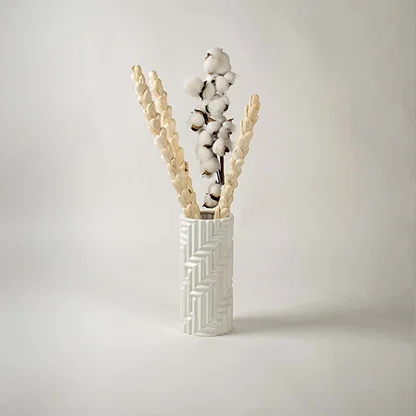 A stylish white textured vase showcased in a minimal lifestyle setup with soft shadows enhancing its sculpted modern design.