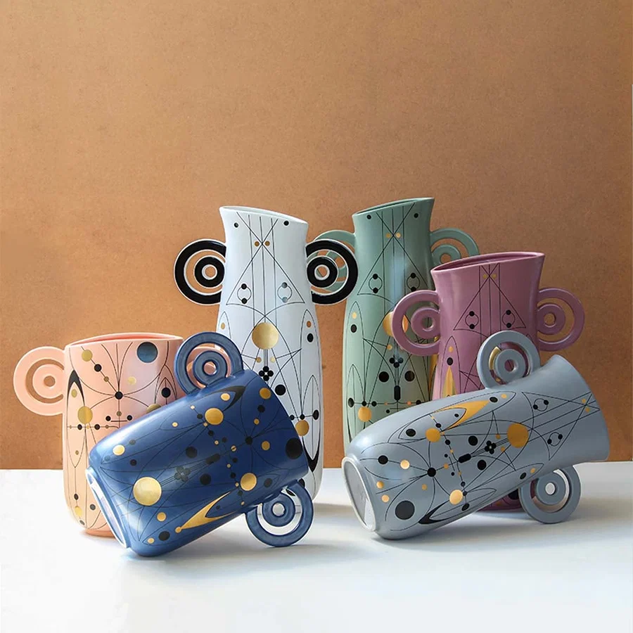 Grey abstract ceramic vase with artistic loop handles styled with matching decor pieces perfect for modern creative home interiors.