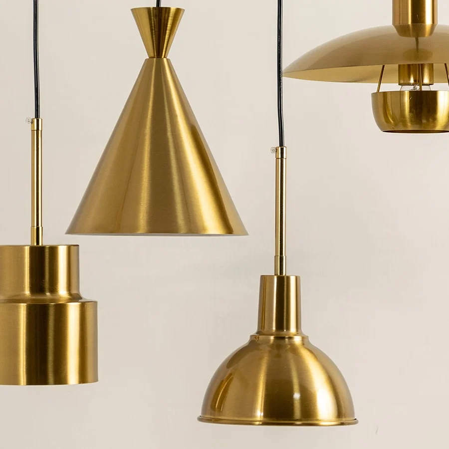 Gold metal pendant lights illuminated to showcase luxury ceiling lighting with elegant contemporary decorative styling.