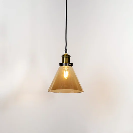 Amber glass cone pendant light illuminated with warm glow and brass metal accents for stylish ceiling lighting decor.