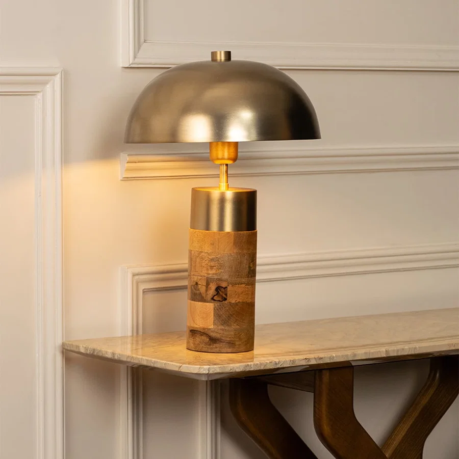 Stylish metal and wood table lamp with a golden dome shade and wooden cylinder base offering soft ambient light and sophisticated modern design.
