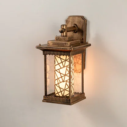 Antique brass outdoor wall light on white background with mosaic pattern inner glass cylinder shade for entryway decor.