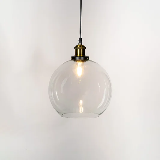 Clear glass pendant light with brass finish metal holder and globe design for elegant modern ceiling lighting decor.