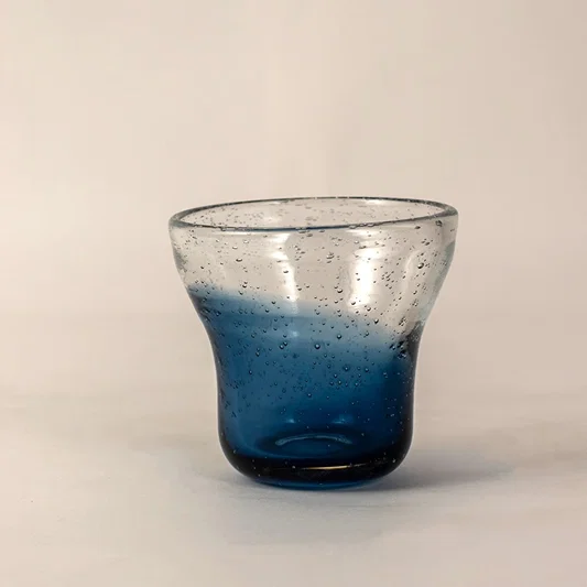 Side angle view of blue bubble glass vase highlighting its unique gradient tones and rounded handcrafted structure.