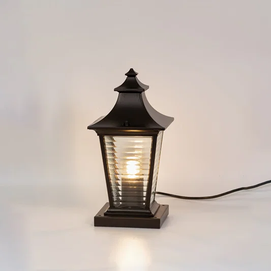 Vintage black outdoor gate light with warm glowing ribbed panels for stylish exterior decor use.