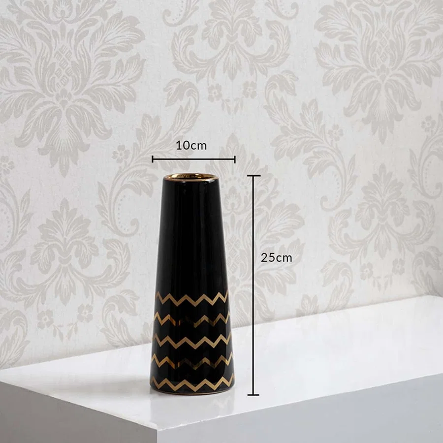 A black ceramic vase with gold zigzag accents shown with measurements of 25 cm height and 10 cm width clearly presenting its decorative size.