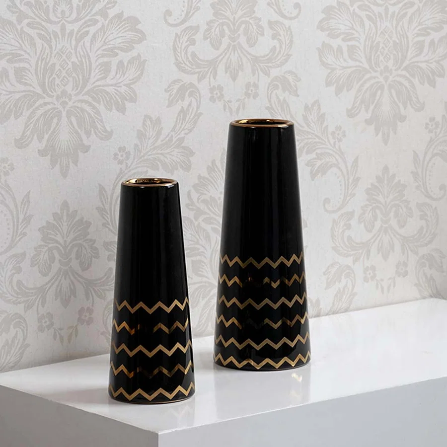 A decorative black vase with gold zigzag design displayed in a curated setup showcasing its modern glossy finish and elegant contemporary look.
