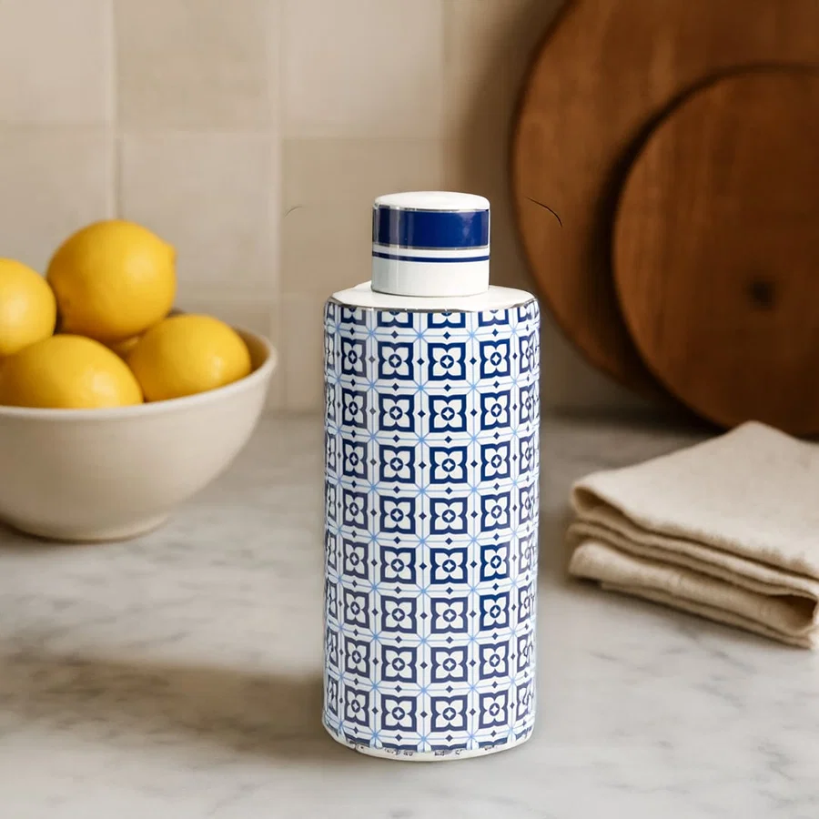 Blue and white ceramic jar with geometric pattern adding charm to kitchen counter with lemons and wooden decor.