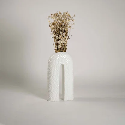 Contemporary ceramic vase styled in interior space bringing elegance and sculptural charm to the setting.