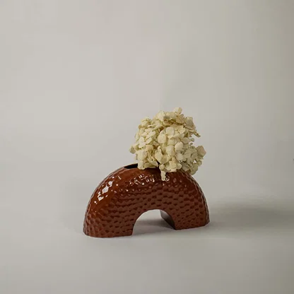 Textured brown arched ceramic vase photographed on a bright white background  highlighting its shape and glossy handcrafted finish.